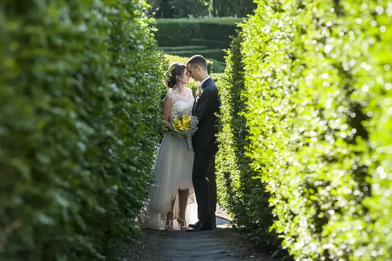 Sposi in fondo a un corridoio di siepi nel giardino di Villa Lante